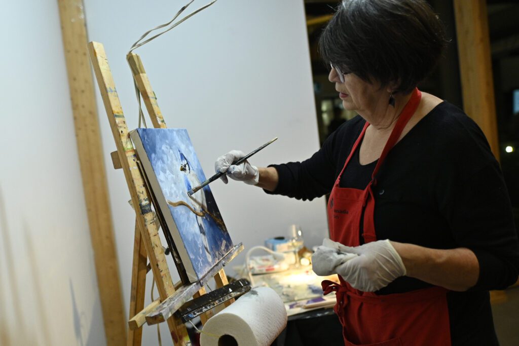 L'artiste-peintre Annette Cormier lors de la réalisation de sa toile en direct.